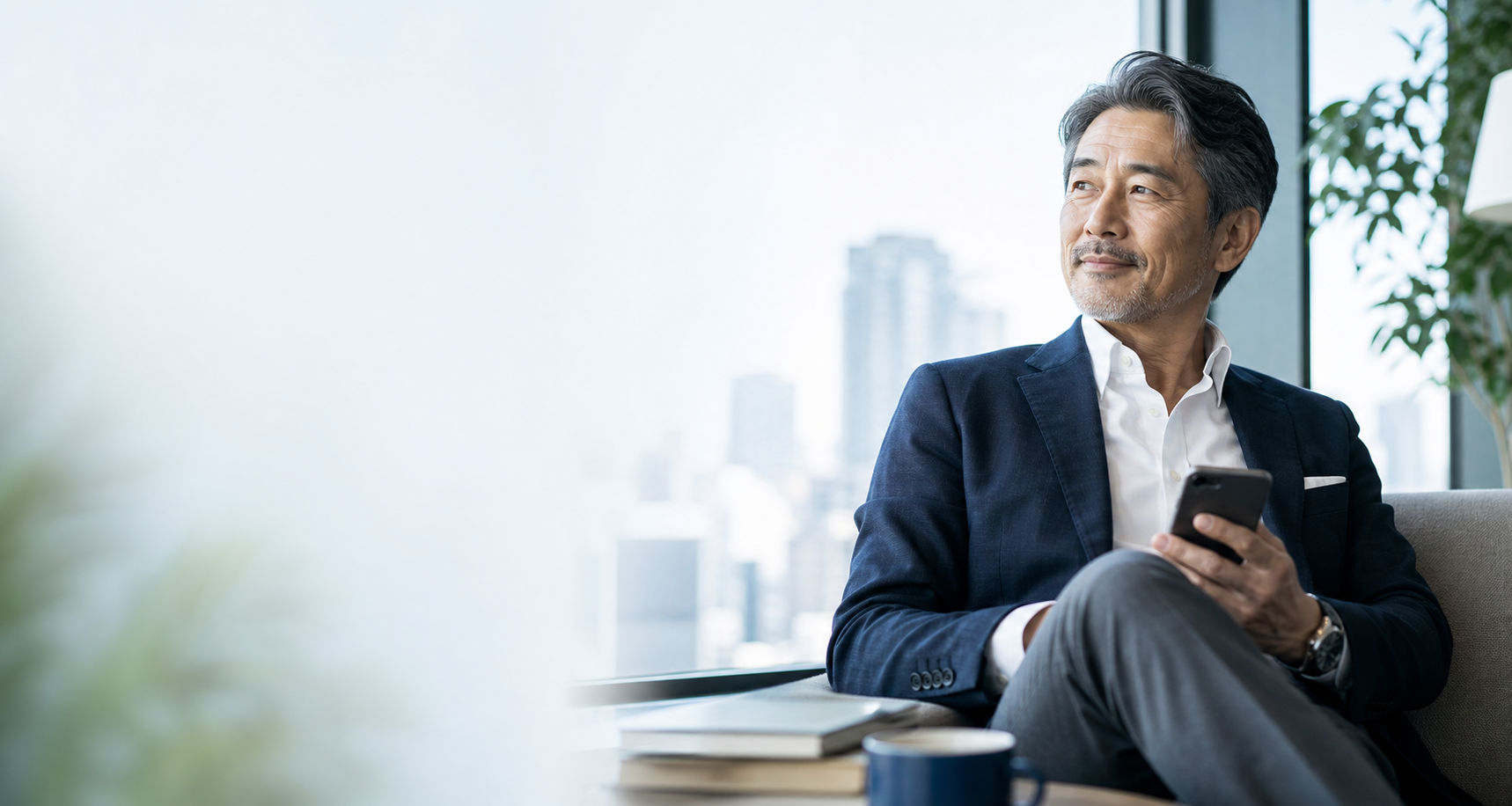 落ち着いた表情でスマートフォンを持つ男性のイメージ